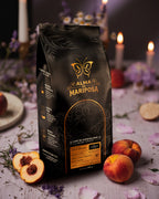 Foto artística bolsa café Geisha Alma de Mariposa con duraznos frescos y velas ambiente relajante