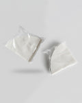 Dos paquetes transparentes de 100 unidades cada uno de filtros de papel blanco para cafetera V60 sobre fondo gris. Repuesto de filtros de alta calidad para café filtrado en Alma de Mariposa.